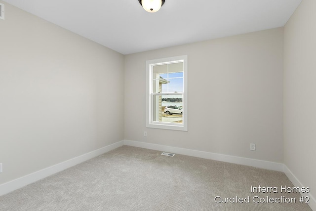 empty room with baseboards, visible vents, and carpet flooring