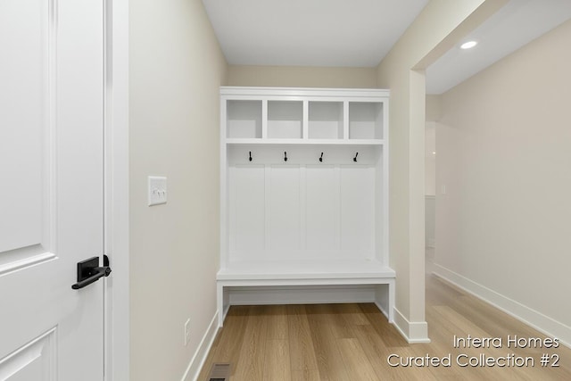 mudroom featuring baseboards, visible vents, and light wood-style floors