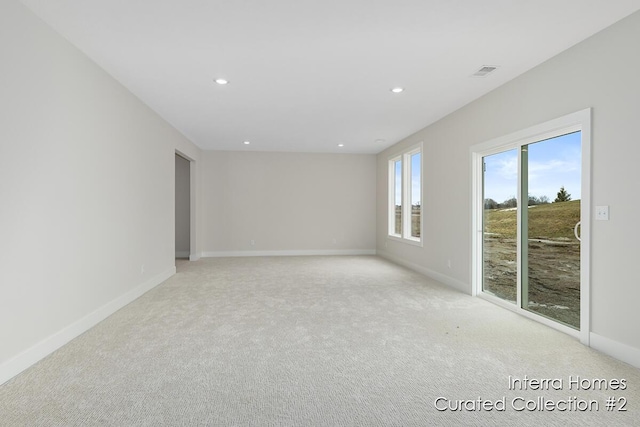 empty room featuring light colored carpet, recessed lighting, visible vents, and baseboards