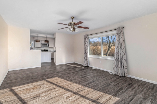 unfurnished living room featuring ceiling fan and dark wood-type flooring