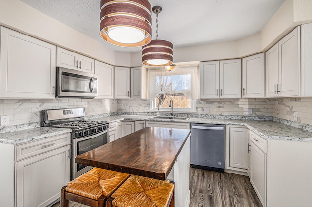 kitchen with butcher block counters, sink, appliances with stainless steel finishes, and tasteful backsplash