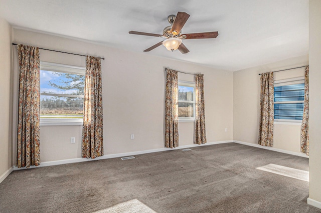 empty room featuring carpet flooring, ceiling fan, and a healthy amount of sunlight