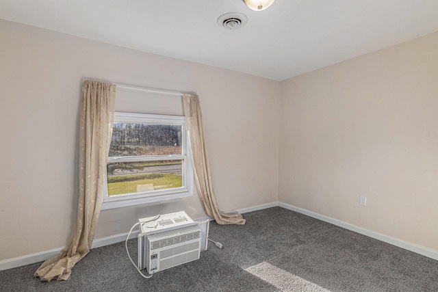 spare room with dark colored carpet and a wall mounted air conditioner