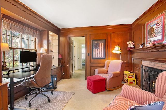 carpeted office featuring wooden walls, ornamental molding, and a brick fireplace