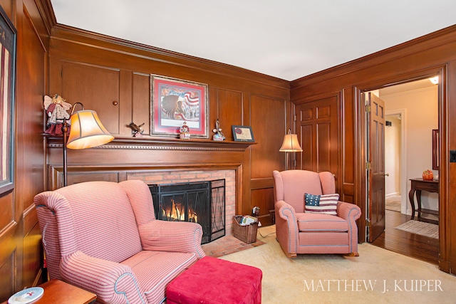 sitting room featuring light carpet, a fireplace, and ornamental molding