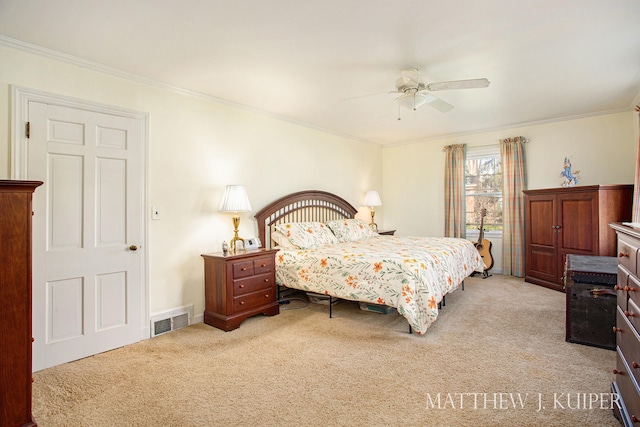 carpeted bedroom featuring ceiling fan and crown molding