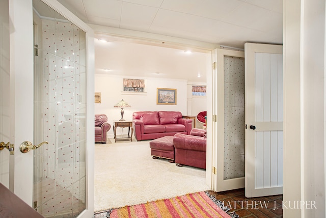 living room featuring dark colored carpet and crown molding