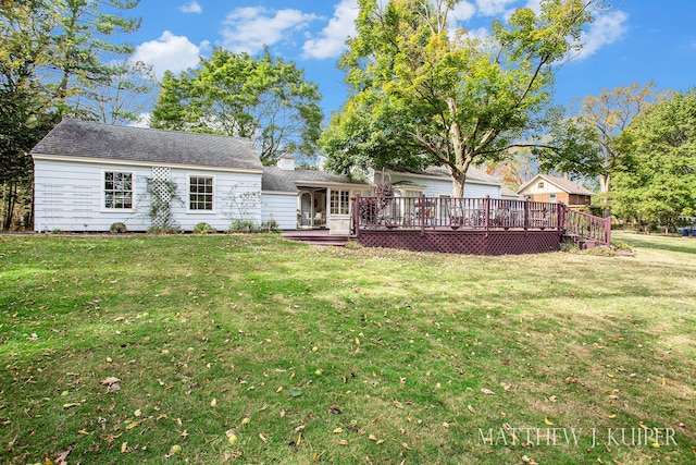 back of house featuring a lawn and a deck