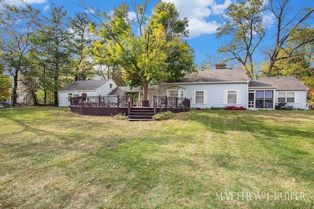 back of property featuring a lawn and a wooden deck