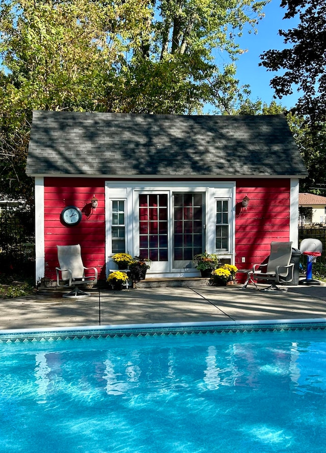 view of swimming pool with an outbuilding and a patio area