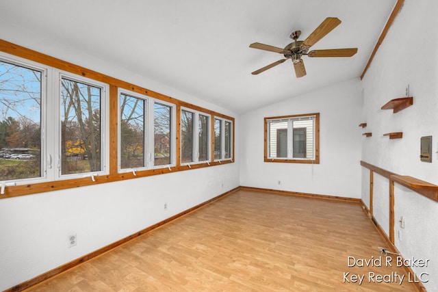 empty room with ceiling fan, plenty of natural light, vaulted ceiling, and light hardwood / wood-style flooring