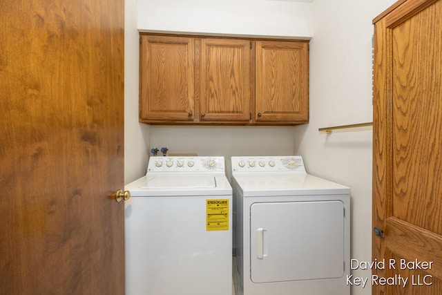 laundry room featuring washing machine and clothes dryer and cabinets