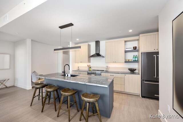 kitchen featuring high quality fridge, electric stove, light brown cabinets, modern cabinets, and wall chimney exhaust hood