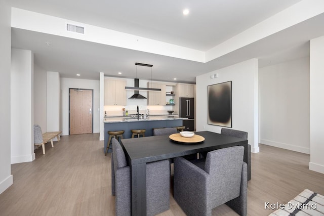 dining space featuring recessed lighting, light wood finished floors, and baseboards