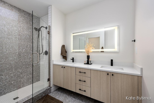 full bathroom with double vanity, a shower stall, and a sink