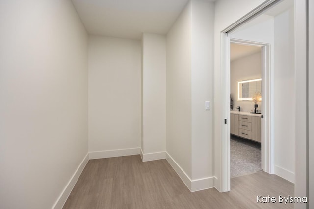 corridor with baseboards and light wood-type flooring