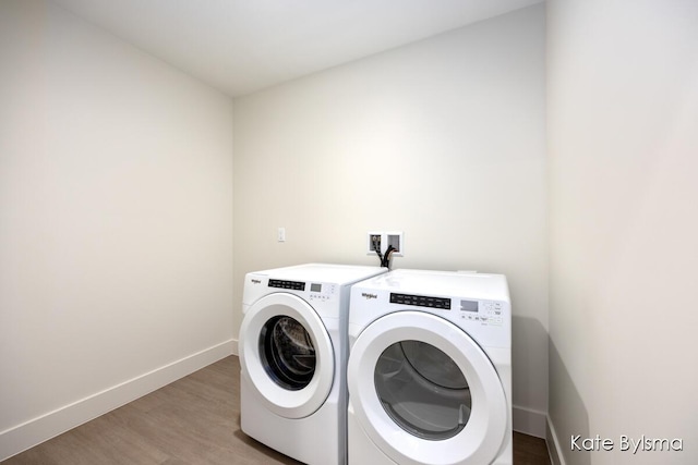 clothes washing area with washer and dryer, baseboards, light wood-style floors, and laundry area