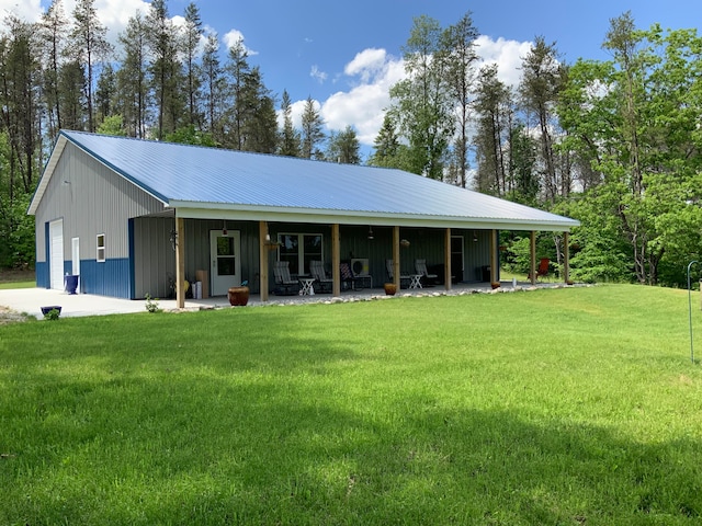 view of front of house with a garage, an outdoor structure, and a front lawn