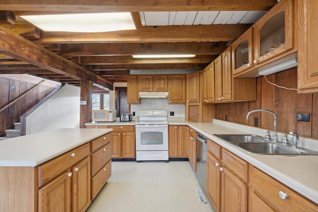 kitchen featuring beamed ceiling, white appliances, wood walls, and sink