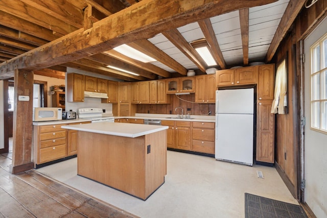 kitchen featuring beam ceiling, white appliances, a center island, and sink