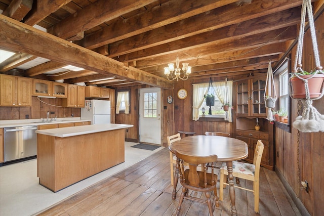 kitchen featuring stainless steel dishwasher, an inviting chandelier, light hardwood / wood-style flooring, a center island, and white fridge