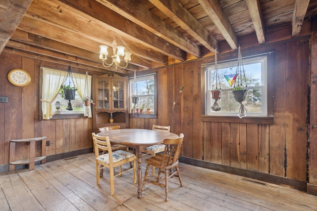 dining area featuring wooden walls and a healthy amount of sunlight