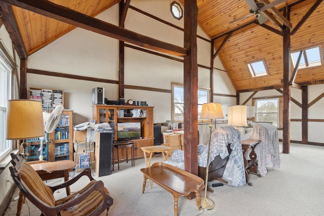 interior space with light carpet, a skylight, wood ceiling, high vaulted ceiling, and beamed ceiling