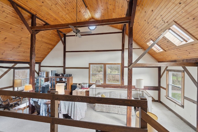 hallway featuring beamed ceiling, wooden ceiling, high vaulted ceiling, and a skylight