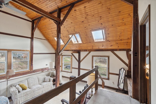 hall featuring beam ceiling, a skylight, high vaulted ceiling, and wood ceiling