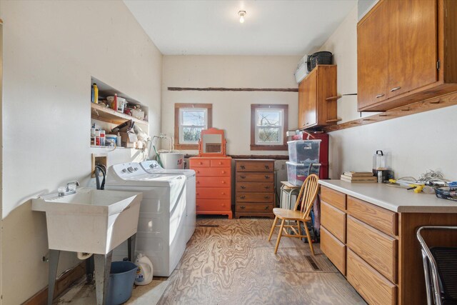 washroom featuring separate washer and dryer, sink, and cabinets