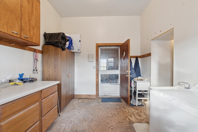 clothes washing area featuring washer / clothes dryer and cabinets