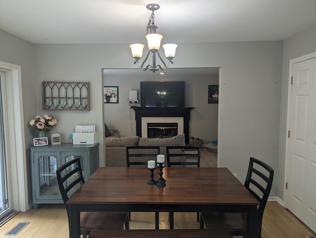 dining area featuring hardwood / wood-style flooring and an inviting chandelier