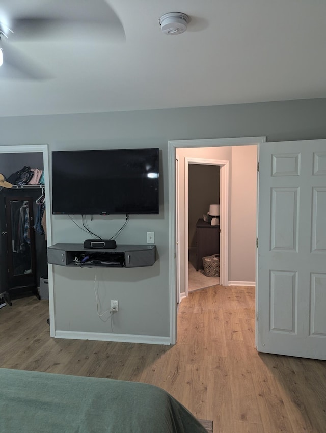 bedroom featuring light wood-type flooring, a spacious closet, and a closet