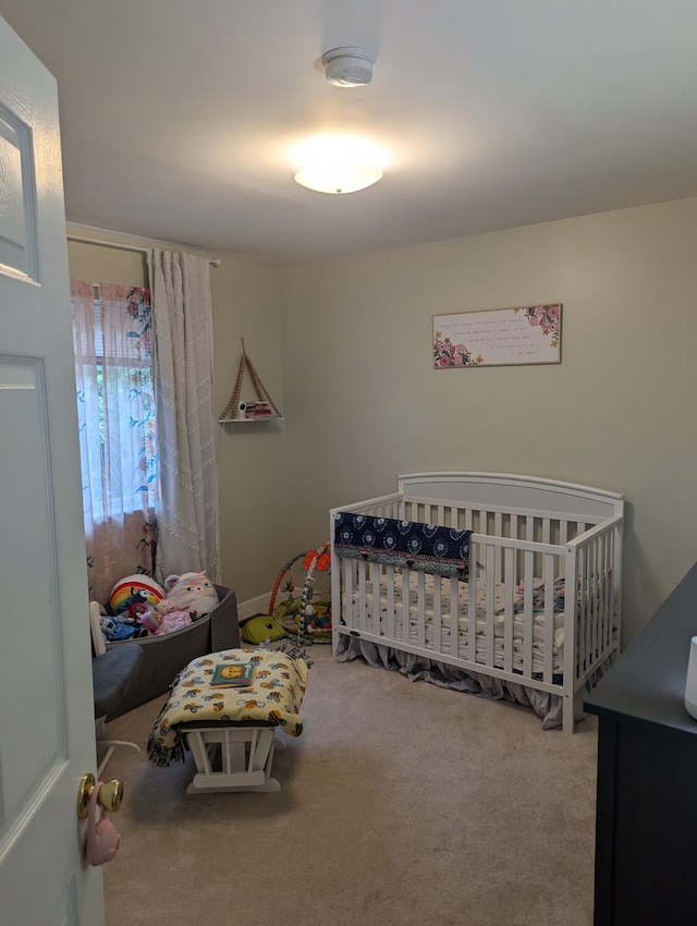 bedroom featuring carpet floors and a nursery area