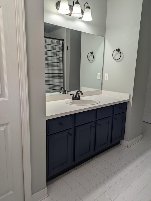 bathroom with a shower with curtain, vanity, and tile patterned floors