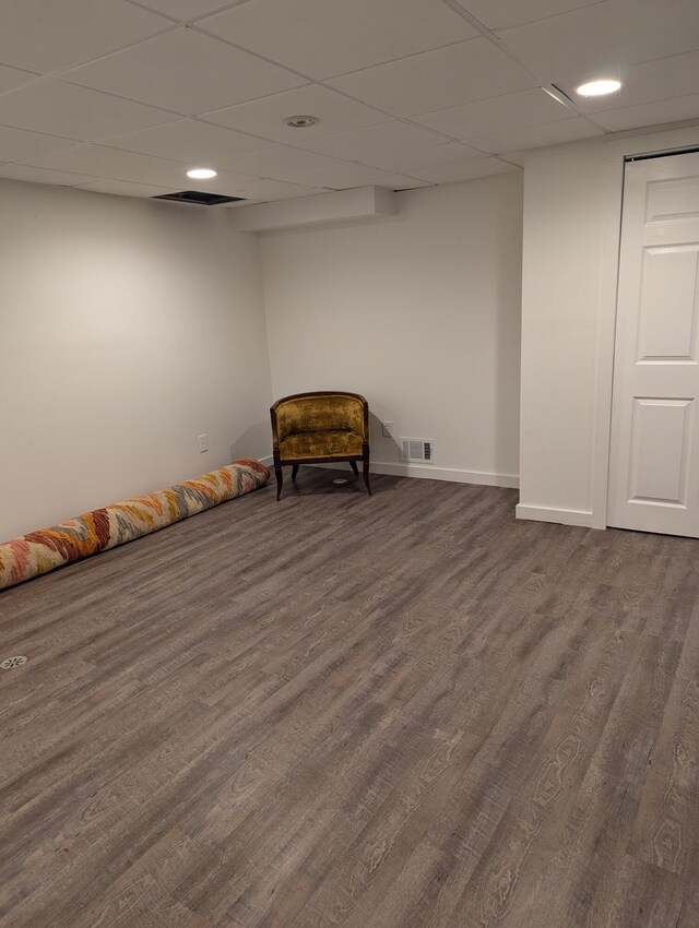 unfurnished room with dark hardwood / wood-style flooring and a paneled ceiling