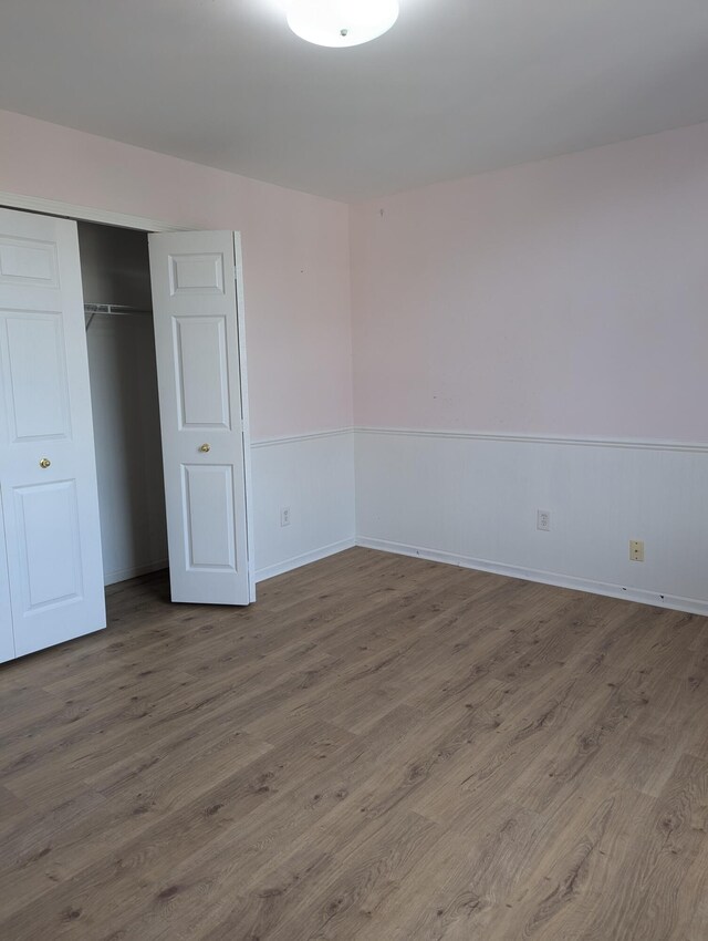 unfurnished bedroom featuring hardwood / wood-style floors and a closet