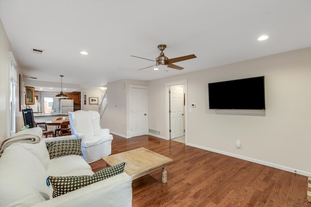 living room with hardwood / wood-style flooring and ceiling fan