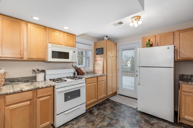 kitchen featuring light stone countertops, light brown cabinetry, and white appliances