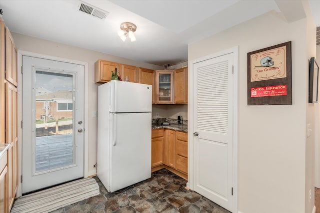 kitchen with white refrigerator and light stone countertops