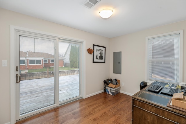 home office with hardwood / wood-style floors and electric panel