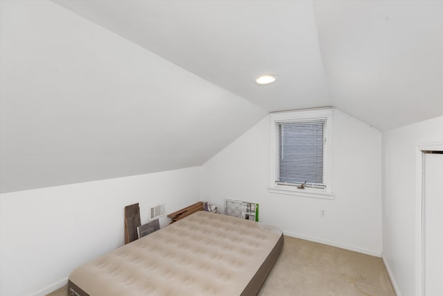 bedroom with light colored carpet and vaulted ceiling