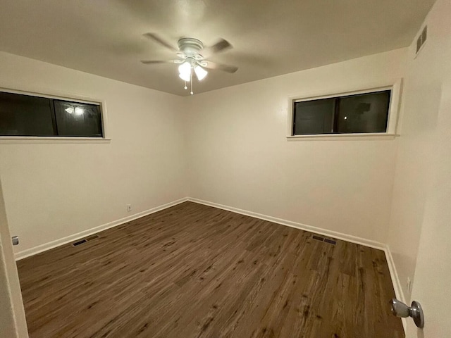 unfurnished room featuring ceiling fan and dark wood-type flooring