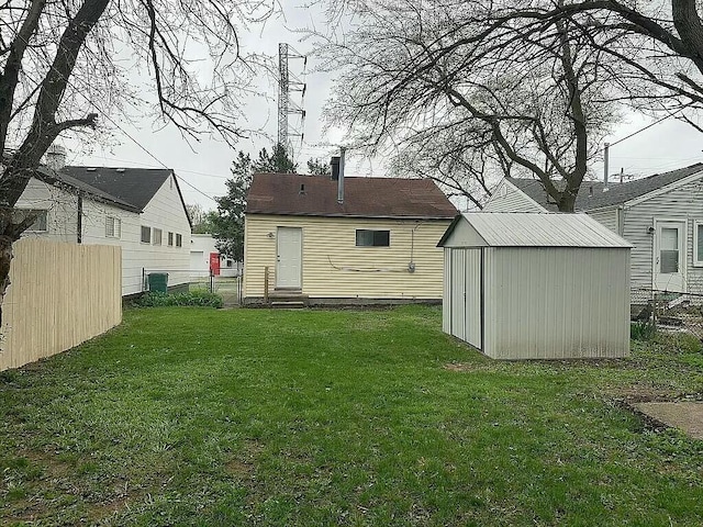 rear view of property featuring a storage unit and a lawn