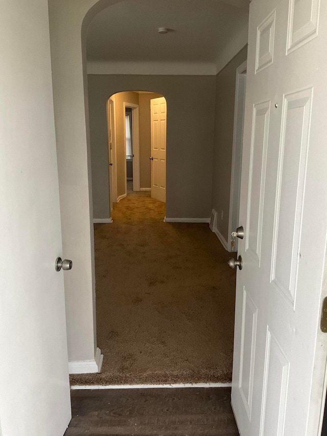 corridor featuring dark colored carpet