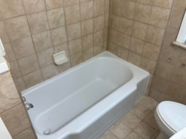 bathroom with tile patterned floors, toilet, and a bathtub