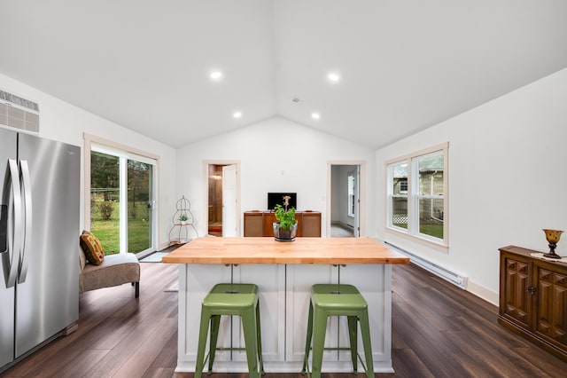 kitchen with a center island, a kitchen breakfast bar, a baseboard radiator, butcher block countertops, and stainless steel fridge with ice dispenser