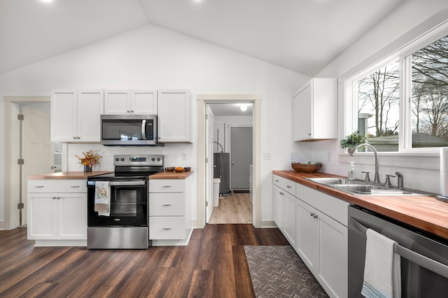 kitchen with white cabinetry, appliances with stainless steel finishes, and wooden counters