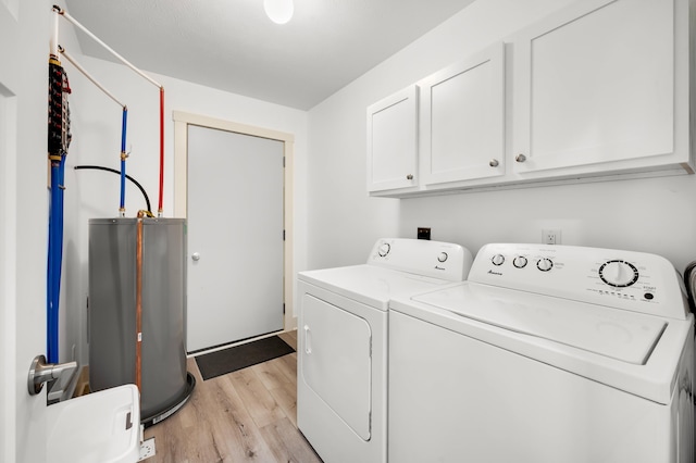 clothes washing area featuring separate washer and dryer, water heater, cabinets, and light wood-type flooring