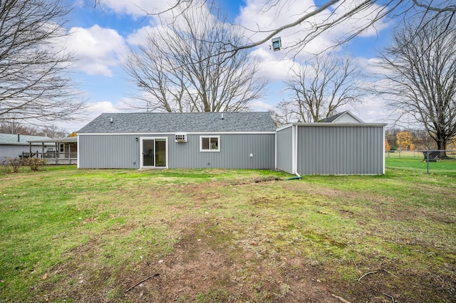 back of house with an outdoor structure and a lawn